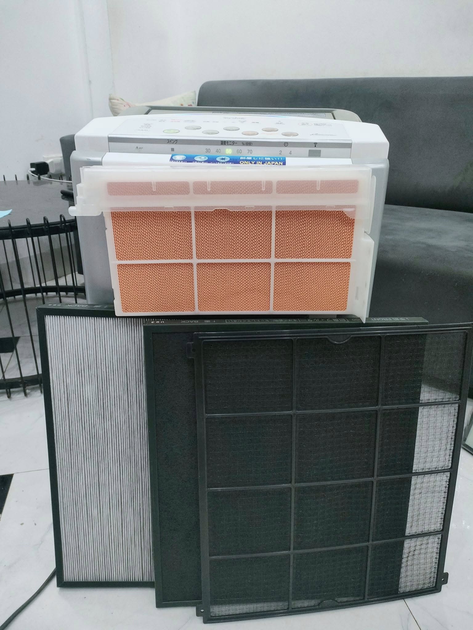 Kỹ thuật viên vệ sinh các tấm lọc sau khi sửa chữa máy hút ẩm Hitachi tại nhà khách hàng